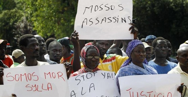 Inmigrantes senegaleses muestran pancartas contra la los Mossos D'esquadra en la manifestació en Salou para protestar por la muerte de un compatriota en una operación contra el 'top manta'. AFP PHOTO / QUIQUE GARCIA