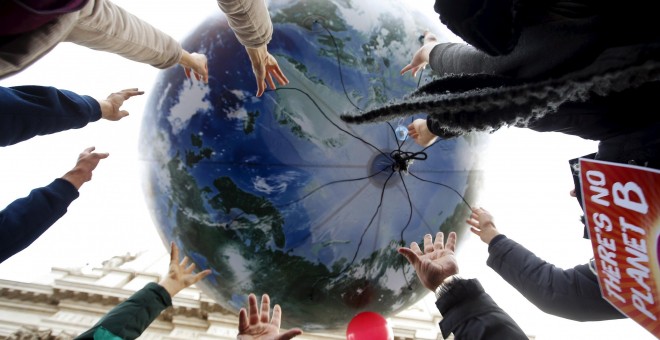 Manifestantes tiran un globo enorme con forma de mundo en la protesta de Roma, Italia, por el cambio climático. REUTERS/Alessandro Bianchi