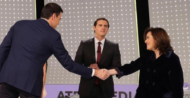 El secretario general del PSOE, Pedro Sánchez (i) saluda a la vicepresidenta del Gobierno y candidata por Madrid al Congreso, Soraya Sáenz de Santamaría, en presencia del presidente de Ciudadanos, Albert Rivera (c) antes del debate televisivo entre los ca