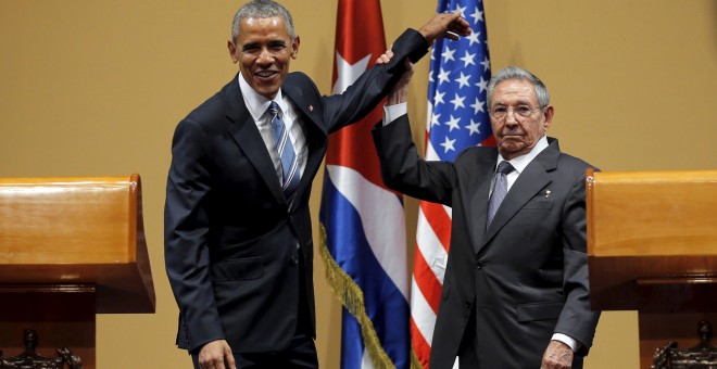 El presidente de Cuba, Raúl Castro, levanta el brazo de Obama tras la conferencia de prensa en el Palacio de la Revolución, en La Habana.- REUTERS