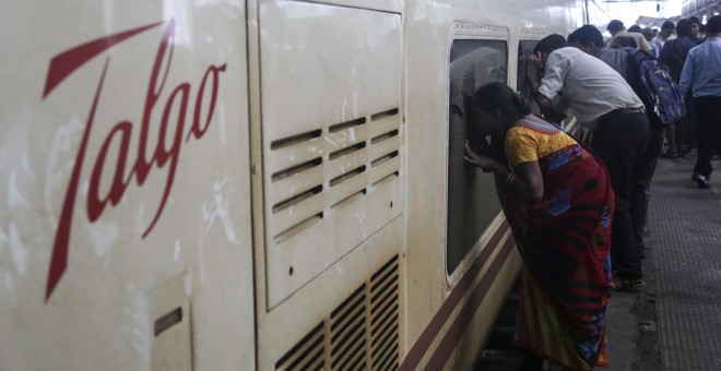 Varias personas observan el interior de uno de los vagones de un tren de la empresa española Talgo a su llegada a la estación central de Bombay. EFE/Divyakant Solanki