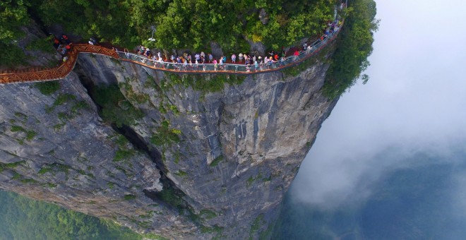 Un grupo de gente camina sobre la plataforma de un mirador en Zhangjiajie, en la provincia de Hunan, China. REUTERS/Stringer