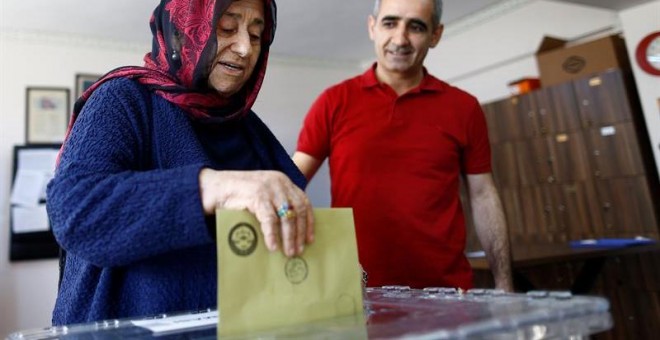 Una mujer deposita su voto al referéndum constitucional en Estambul. EFE/Sedat Suna