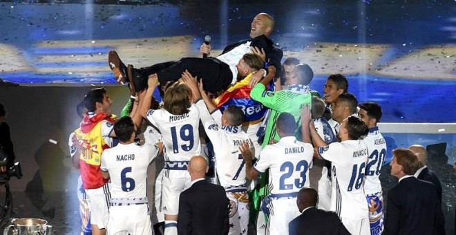 Los jugadores del Real Madrid mantean al técnico francés del equipo blanco, Zinedine Zidane, durante la celebración que el equipo madridista ha organizado esta noche en el estadio Santiago Bernabéu / EFE