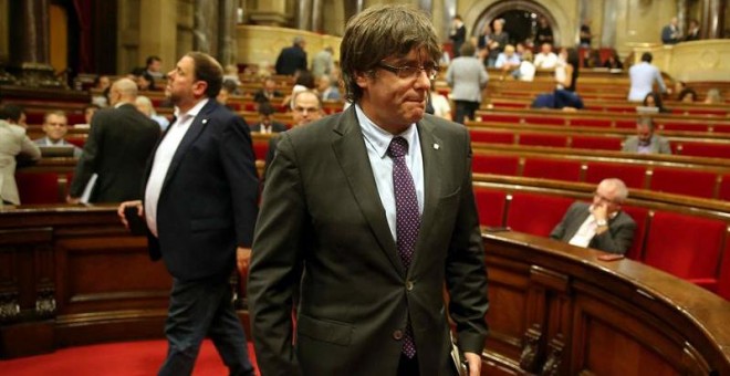 El presidente de la Generalitat, Carles Puigdemont (d) y el vicepresidente del Govern, Oriol Junqueras (i), abandonan hoy el hemiciclo del Parlament de Catalunya. EFE/Toni Albir