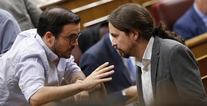 El secretario general de Podemos, Pablo Iglesias (d), conversa con el coordinador general de IU, Alberto Garzón (i). /EFE