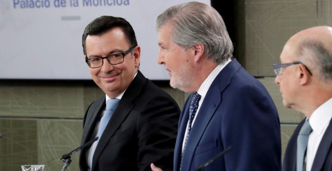 El ministro de Economía Román Escolano (i), el ministro Portavoz Iñigo Méndez de Vigo (c), y el ministro de Hacienda Cristóbal Montoro, durante la rueda de prensa posterior al Consejo de Ministros, celebrado en el Palacio de La Moncloa. EFE/Zipi