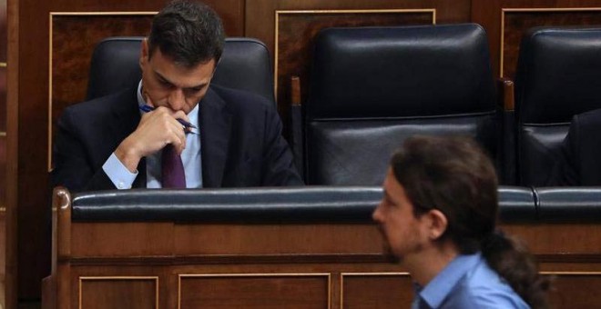 El líder de Podemos, Pablo Iglesias, pasa ante el jefe del Ejecutivo, Pedro Sánchez, durante el pleno del Congreso. (BALLESTEROS | EFE)