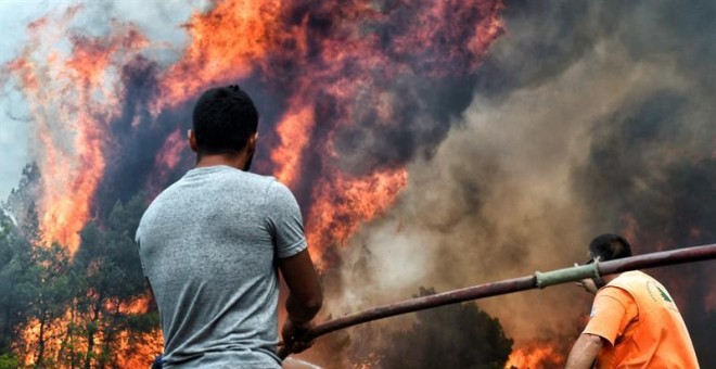 Varios bomberos y voluntarios luchan contra las llamas en un incendio en Verori/EFE