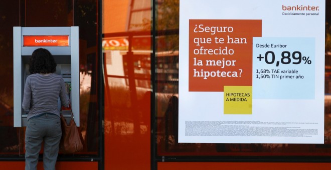 Una mujer en un cajero automático de una oficina de Bankinter en el centro de Madrid. REUTERS/Sergio Perez