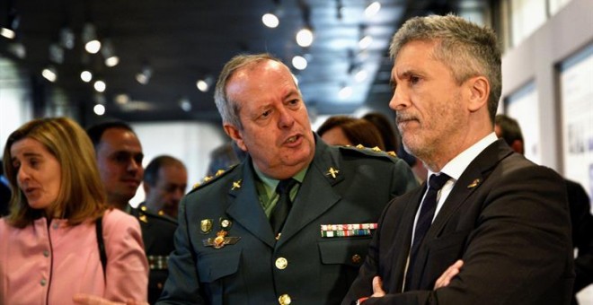 El ministro del Interior, Fernando Grande-Marlaska, atiende las explicaciones durante la inauguración de la exposición 'La Guardia Civil,175 años a tu lado', este jueves en la sala de exposiciones 'La Arquería', en Madrid. EFE/ Carlos Perez