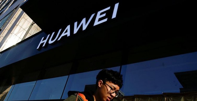 Imagen de un usuario de móvil frente a una tienda de Huawei. REUTERS