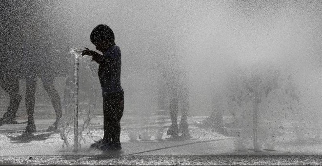 29/06/2019.- Varios jóvenes combaten las altas temperaturas registradas en Pamplona refrescándose en una de las fuentes de la capital navarra. EFE/Villar López