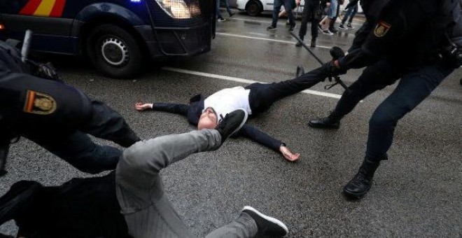 Agentes de la Policía Nacional arrastran a varios de los concentrados en un colegio electoral de Barcelona durante la jornada del referéndum del 1 de octubre de 2017. REUTERS/Susana Vera