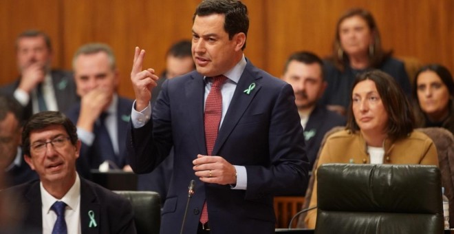 Juan Marín, sentado, y Juanma Moreno, de pie, con los lazos con la bandera de Andalucía en la solapa. Europa Press