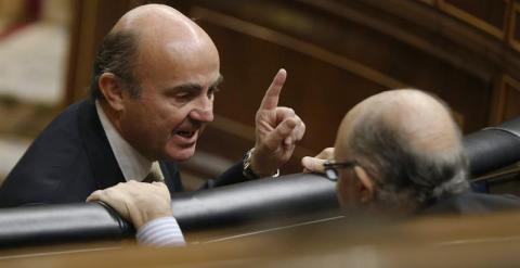 El ministro de Economía, Luis de Guindos, conversa con el titular de Hacienda, Cristóbal Montoro, en el Congreso de los Diputados. EFE/Paco Campos