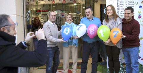 Los empleados de la administración de loteria que ha repartido el cuarto premio con el número 07617, posan con los números premiados en globos, en la capital vizcaina durante el tradicional sorteo navideño. EFE/LUIS TEJIDO