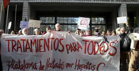 Varias personas participan en una cadena humana, organizada por la Plataforma de Afectados por la Hepatitis C, rodeando el Ministerio de Sanidad para exigir tratamientos para la enfermedad.- EFE/Ballesteros