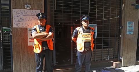 Dos policías argentinos custodian la entrada al domicilio de Nisman, por delante de un cartel colocado por un ciudadano en el que se lee 'Yo soy Nisman'. REUTERS