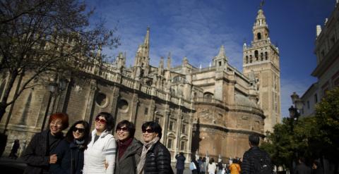 Un grupo de turista posa para una foto junto a la Catedral de Sevilla. REUTERS/Marcelo del Pozo