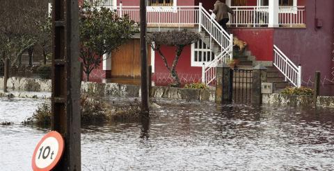 Vecinos de la localidadad cantabra de Ampuero intentan que la lluvia no entre en su domicilio. EFE