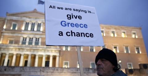 Un manifestante sostiene una pancarta que dice 'Dad una oportunidad a Grecia', en la concentración en apoyo del primer ministro Alexis Tsipras, en la Plaza Sintagma, de Atenas. REUTERS