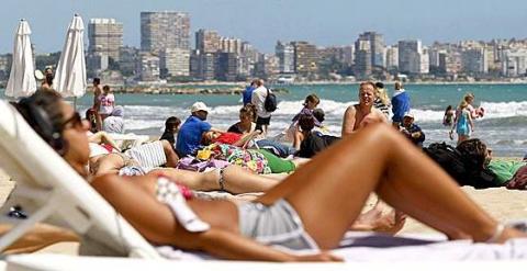 Turistas toman el sol en la playa del Postiguet, en Alicante. (EFE/ARCHIVO)