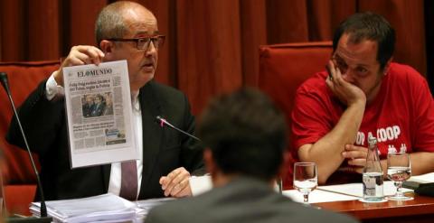 El conseller de Empresa, Felip Puig (i), junto al presidente de la comisión de investigación de fraude fiscal del Parlament de Cataluña, el diputado de la CUP David Fernández (d), muestra un recorte de prensa durante su intervención hoy ante esta comisión