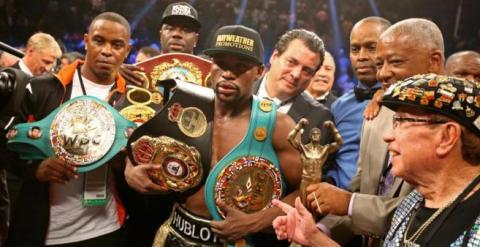 Mayweather con los cinturones de campeón./ REUTERS