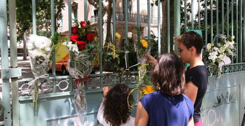 Flores depositadas a la entrada de la escuela María Cortina de Reus por alumnos del centro donde un menor de cinco años resultó el jueves herido grave al caerle una rama a causa del viento. EFE/Jaume Sellart