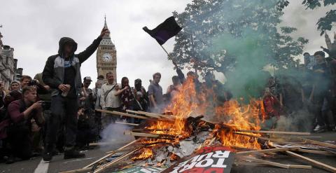 Los manifestantes queman pancartas durante la protesta en Londres. REUTERS/Peter Nicholls