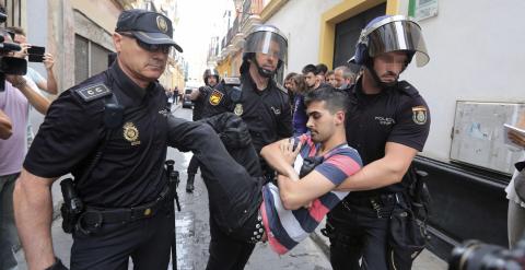 Agentes de la Policía Nacional llevan a una de las personas que intentaban evitar un desahucio a una familia que vivía en su casa de Cádiz en régimen de alquiler pero que finalmente ha sido desalojada por orden judicial. EFE/ Román Ríos