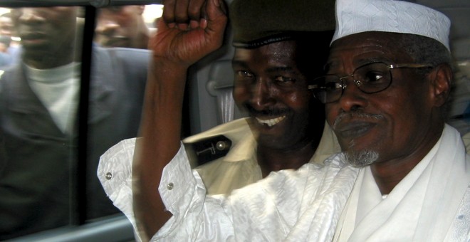 El ex presidente de Chad Hissène Habré (D) levanta su puño cuando sale de un tribunal de Dakar escoltado por un policía senegalés en esta foto de archivo del 25 de noviembre 2005./ REUTERS