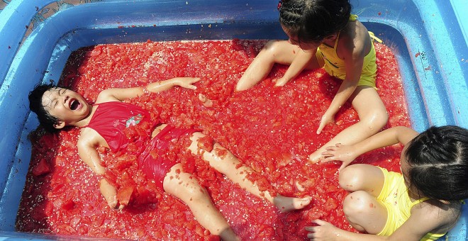 Unos niños juegan en una piscina llena de sandía para refrescarse en un parque de atracciones en Hangzhou, provincia de Zhejiang, China, 22 de julio de 2015. REUTERS / Stringer,