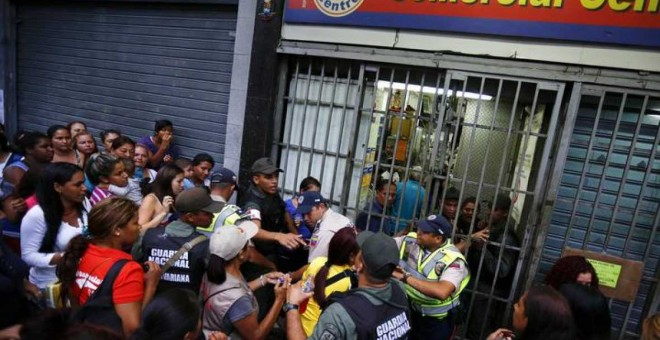 Gente haciendo cola delante de un supermercado en Caracas para comprar papel higiénico y pañales. -REUTERS /Jorge Silva