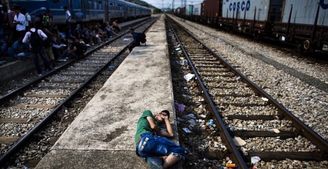 Un inmigrante descansa sobre una plataforma en la estación de tren en Gevgelija. Muchos inmigrantes tratan de cruzar Macedonia y Serbia para entrar en la Unión Europea a través de Hungría, un país terminará de construir su valla anti-inmigrante en su fron