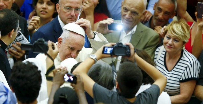 Pope Francis wears a skull cap he received from a faithful as he arrives to lead his Wednesday general audience in Paul VI hall at the Vatican Pope Francis wears a skull cap he received from a faithful as he arrives to lead his Wednesday general audience