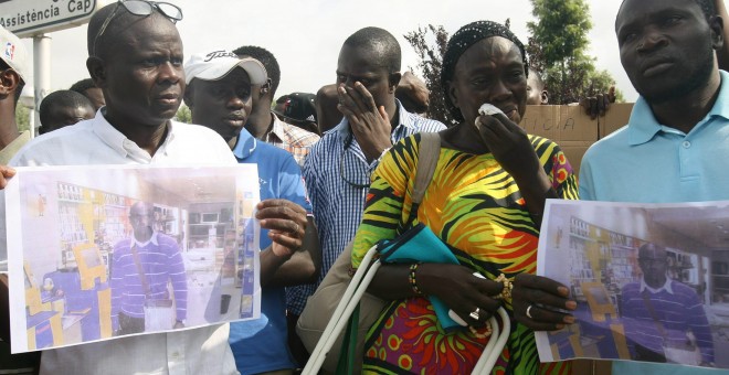 Ibraim Sylla (c, con camisa a cuadros), hermano de Mor, el vendedor ambulante muerto ayer al lanzarse desde un balcón al huir de los Mossos durante una operación contra la venta ilegal ambulante, llora junto al resto de senegaleses, unos doscientos, que s