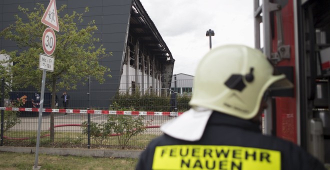 Un bombero alemán junto al edificio incendiado en Neuen, cerca de Berlín, que estaba siendo habilitado para ser un centro para refugiados. REUTERS/Axel Schmidt