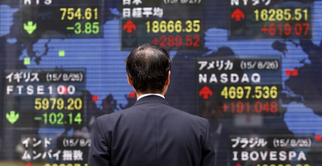 Un hombre observa los valores bursátiles en la Bolsa de Tokio. /REUTERS