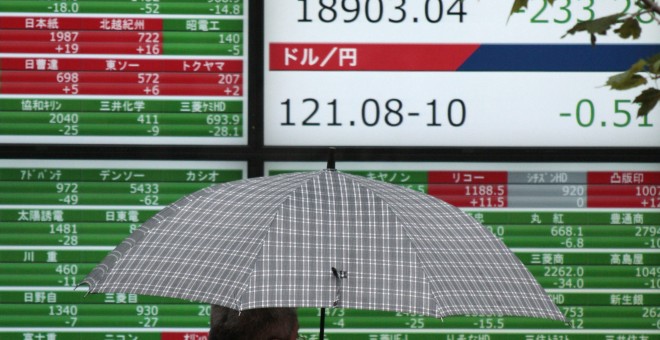 Un hombre camina junto a una pantalla que muestra información bursátil en Tokio. EFE/Kimimasa Mayama