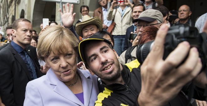 La canciller alemana Angela Merkel (i) posa para un selfie en Berna, Suiza, hoy, 3 de septiembre de 2015. Merkel realiza una visita oficial de un día al país. EFE/PETER SCHNEIDER / POOL