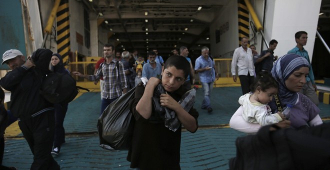 Refugiados, en su mayoría sirios, desembarcan en el puerto del Pireo, en Atenas, del ferry 'Eleftherios Venizelos', que los traslada desde las islas griegas de Lesbos y Kos, donde llegaron desde Turquía. EFE/EPA/YANNIS KOLESIDIS