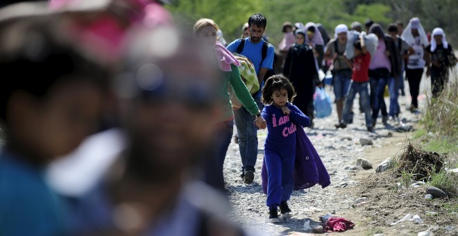 Los migrantes caminan hacia un campo de refugiados en Gevgelija, Macedonia, después de entrar en el país por el cruce de la frontera con Grecia. REUTERS