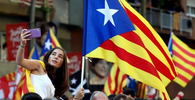 Una joven se hace una foto en la Meridiana de Barcelona donde esta tarde se está celebrando la manifestación con motivo de la Diada. EFE/Toni Albir