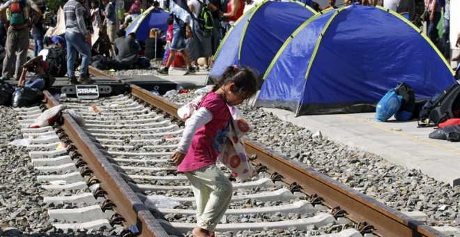 Refugiados descansan en tiendas de campaña instaladas en la estación de Tovarnik, Croacia. EFE/Antonio Bat