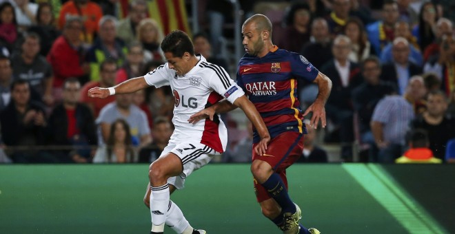 El jugador del Barça Mascherano disputa un balón al jugador del Bayer Leverkusen Javier Hernandez, 'Chicharito', en el partido de Liga de Campeones, en el Camp Nou. REUTERS/Sergio Perez