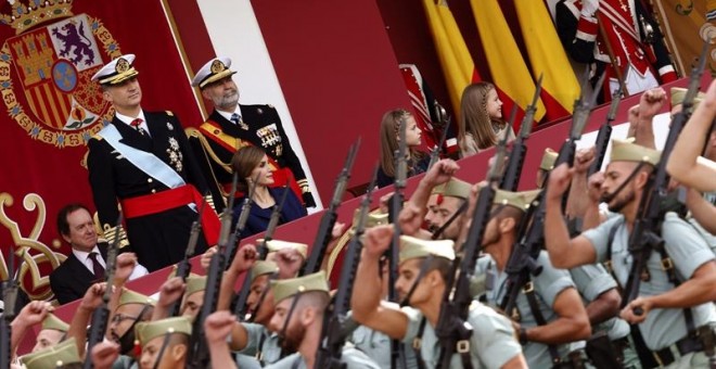 Los Reyes, acompañados de sus hijas la princesa Leonor y la infanta Sofía, presiden en la plaza de Cánovas del Castillo, el desfile del Día de la Fiesta Nacional./ EFE