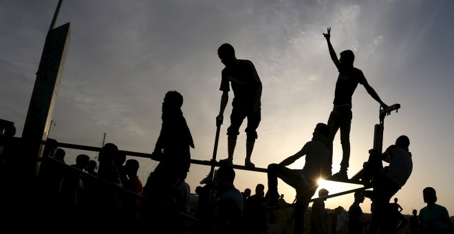 Manifestantes palestinos se sitúan en la valla fronteriza durante los enfrentamientos con las tropas israelíes cerca de la frontera entre Israel y el centro de la Franja de Gaza 13 de octubre de 2015. REUTERS / Ibraheem Abu Mustafa