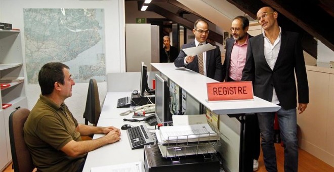 Raül Romeva y Jordi Turull, de Junts pel Sí (JxSí), y Antonio Baños, de la CUP, tras presentar el anexo./ EFE